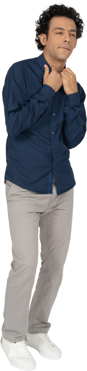 Front view of a man in casual clothes touching collar on his shirt