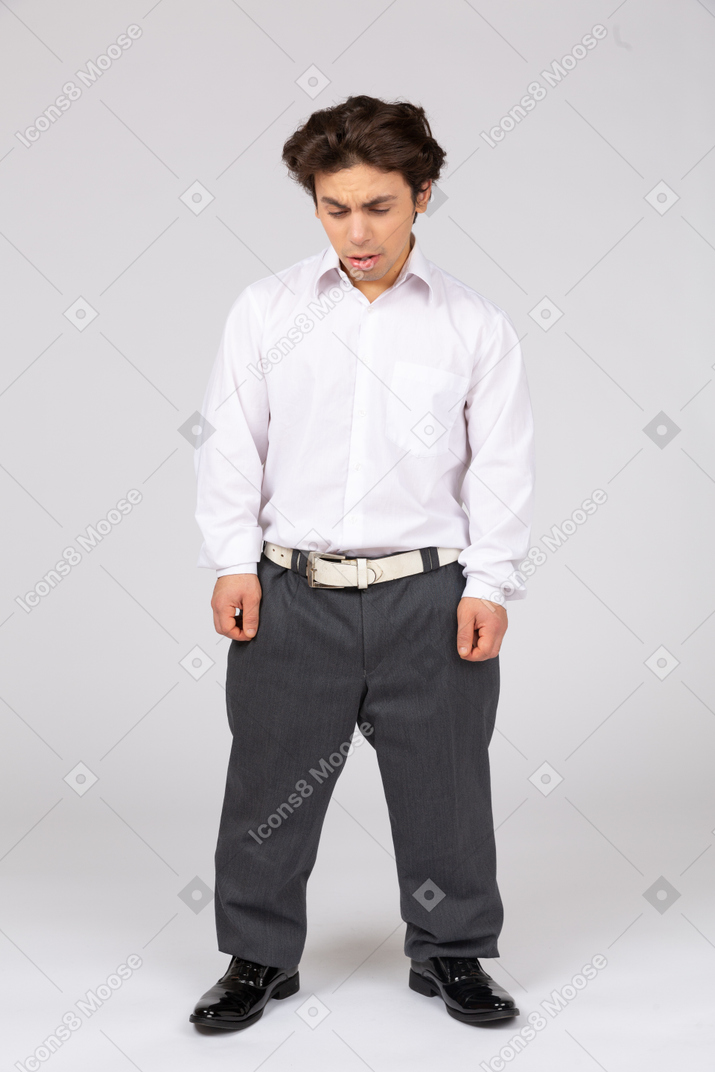Young man in business casual clothes looking down