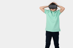 Junge im virtual-reality-headset berührt seinen kopf