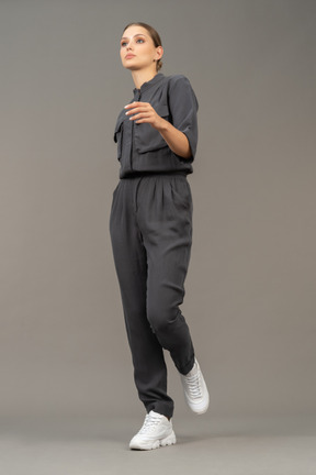 Three-quarter view of a walking young woman in a jumpsuit