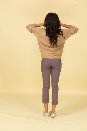Back view of a dark-skinned young female closing her eyes