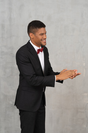 Side view of a young man clapping