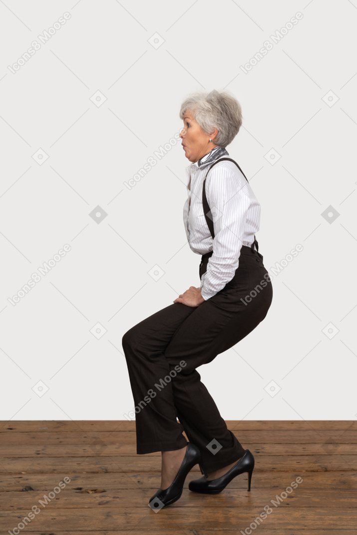 Side view of a woman in office clothes doing half squat