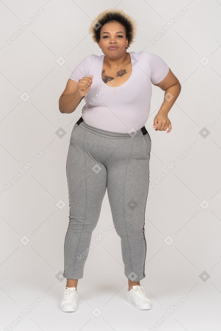 Excited black woman in sport apparel dancing to the tune