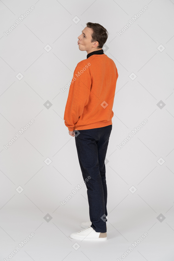 Young man in orange sweatshirt standing