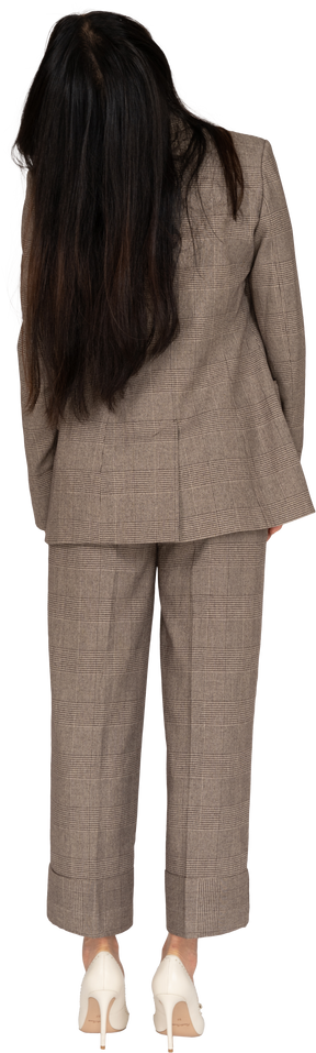 Back view of a young lady in brown business suit tilting head