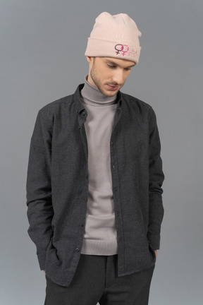 Uomo premuroso in cappello rosa in piedi ancora