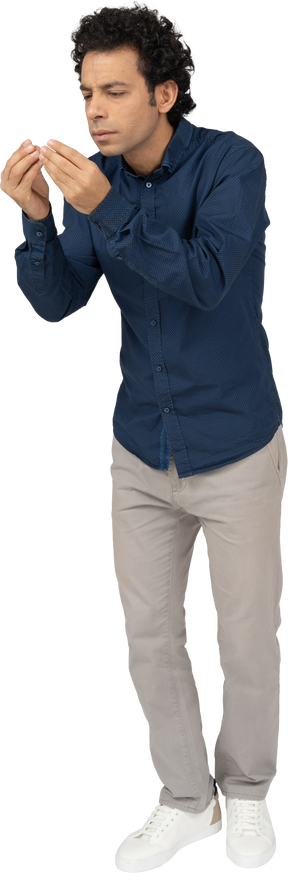 Vista frontal de um homem em roupas casuais mostrando o tamanho de algo
