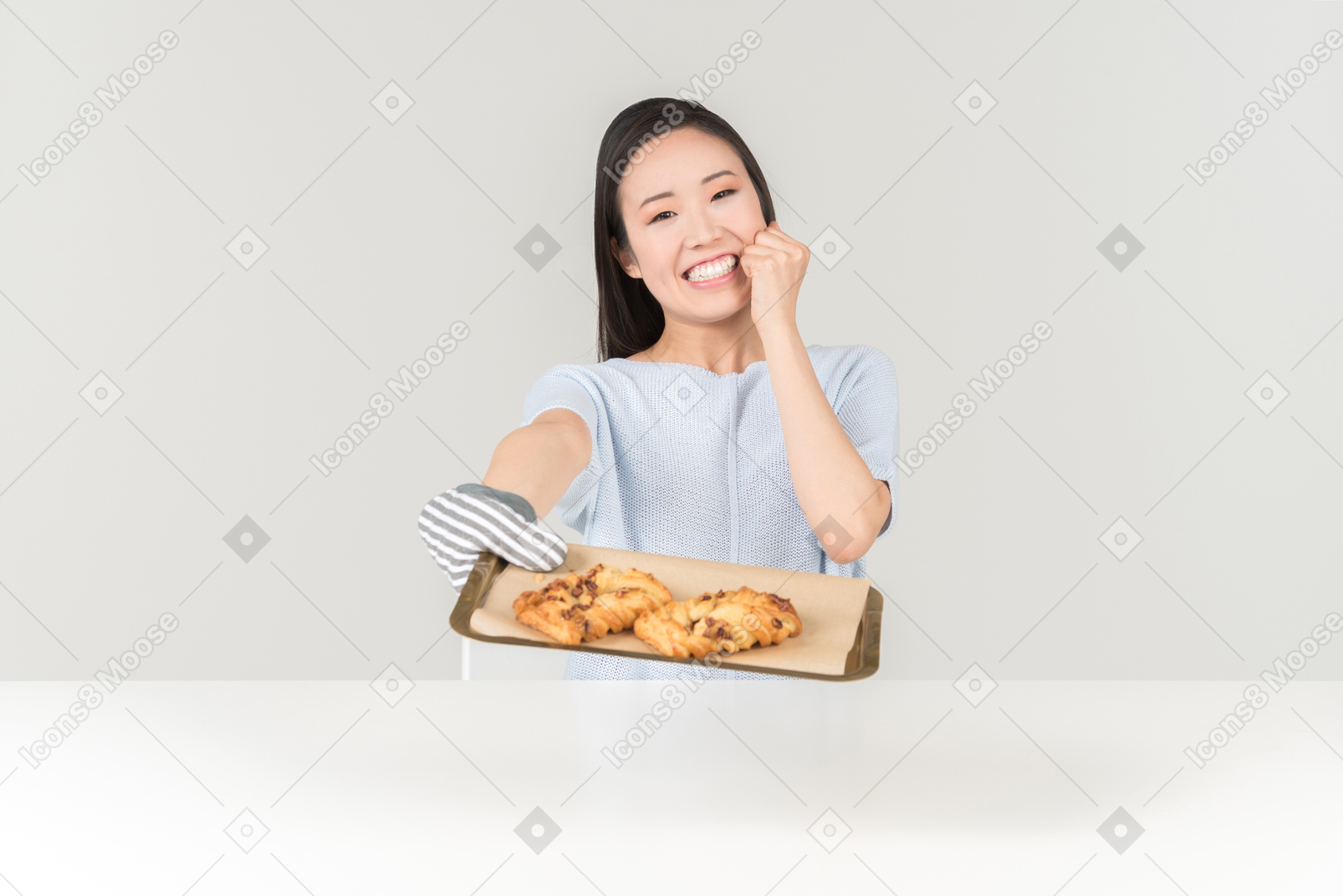 Sorridente jovem mulher asiática segurando a bandeja com cookies