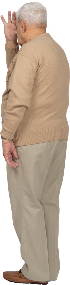 Vista lateral de um velho em roupas casuais, olhando por entre os dedos