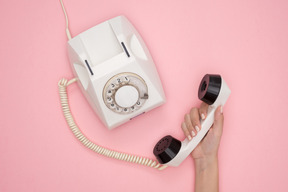 Female hand holding vintage phone receiver