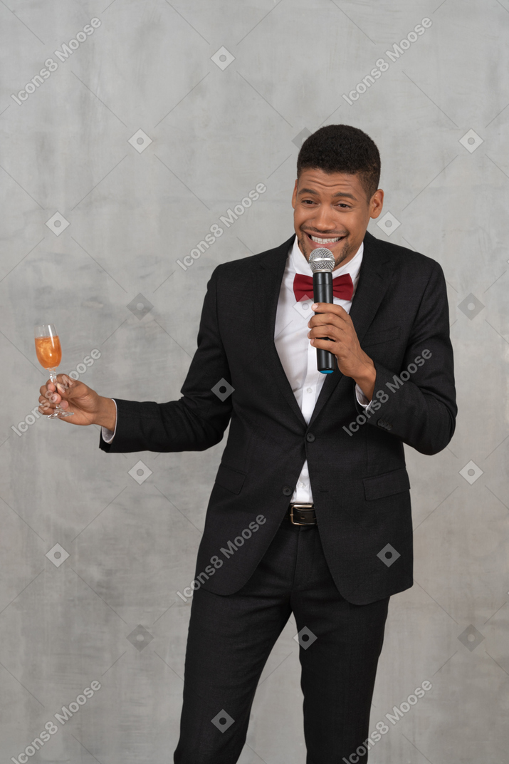 Young man with mic and flute glass talking