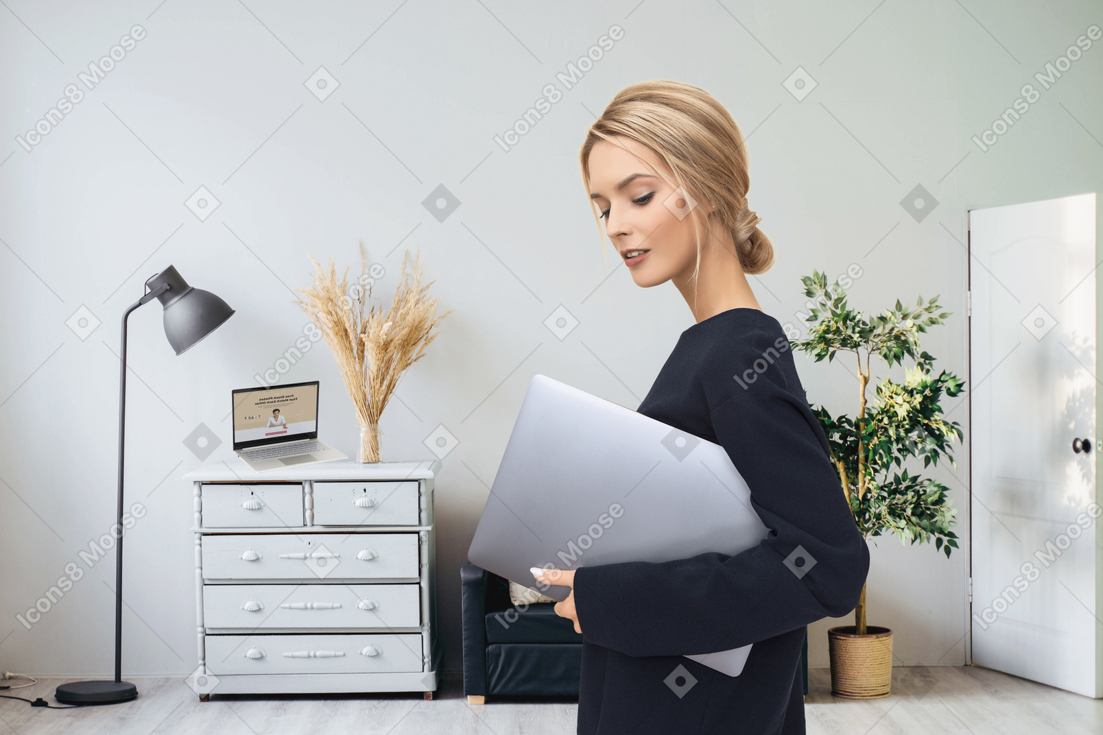Femme debout avec un ordinateur portable dans une chambre