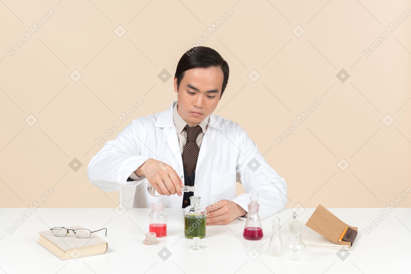 Uno scienziato asiatico in camice bianco che sta lavorando a un esperimento chimico