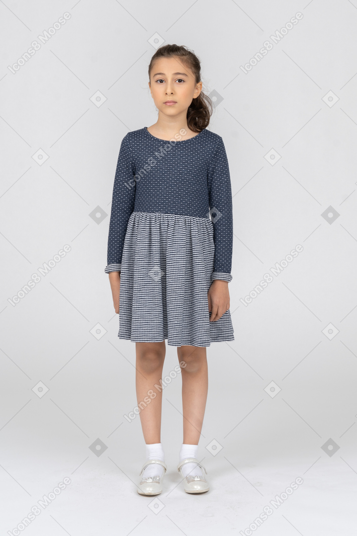 一个穿着灰色裙子站着的女孩的全长