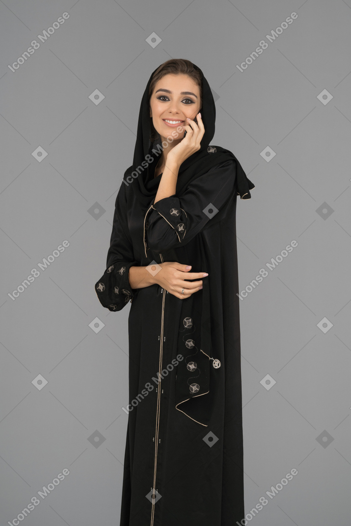 Smiling muslim woman talking on a phone