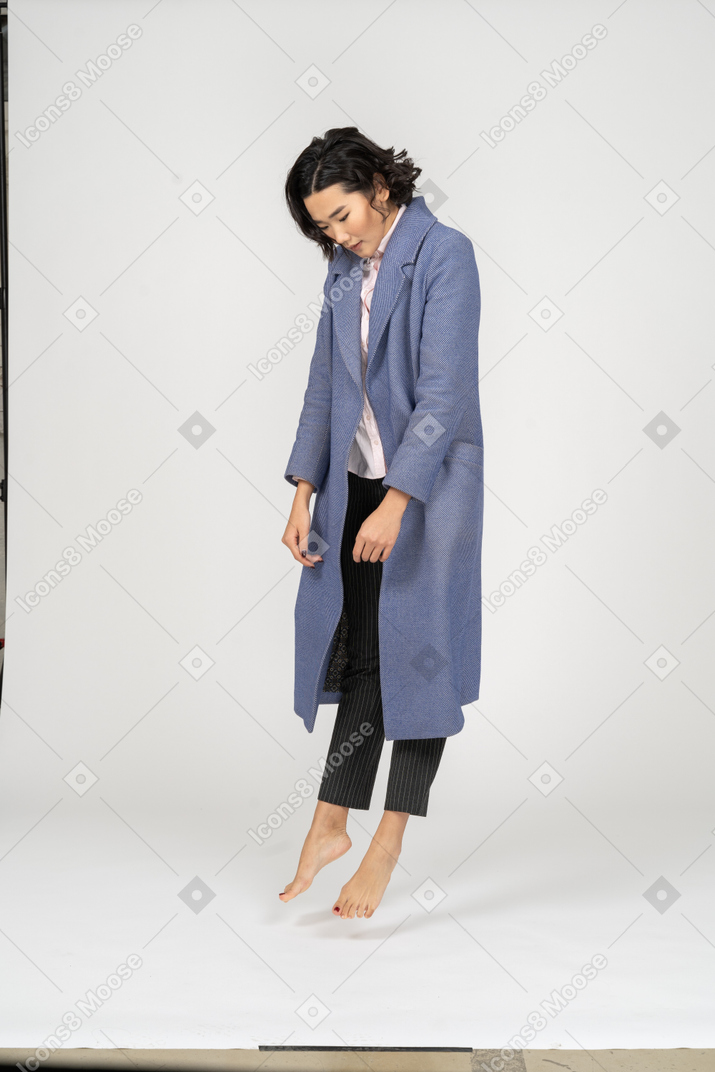 Woman in coat levitating