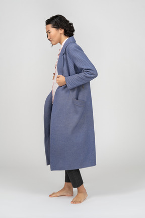 Side view of a frowning woman adjusting coat