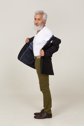 Side view of a man taking off his jacket