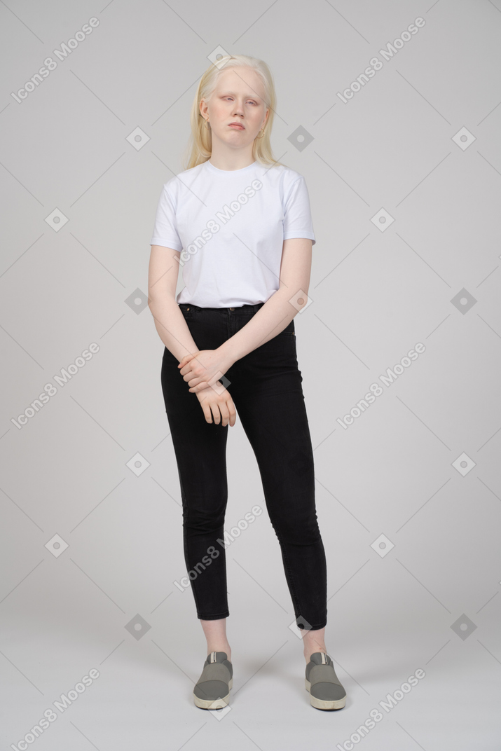 Vista frontale di una giovane donna in piedi e tenendo il braccio
