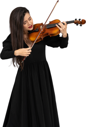 バイオリンを弾く黒いドレスを着た若い感情的な女性のクローズアップ
