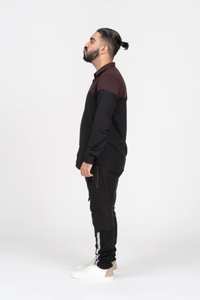 A young man standing sideways