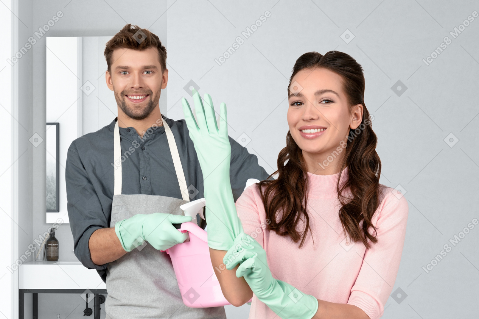A man and a woman wearing cleaning gloves in a bathroom