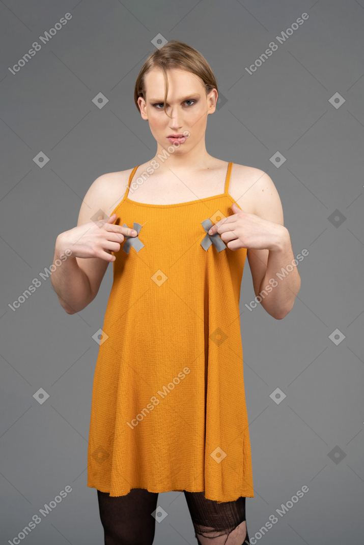 Front view of a young non-binary person touching chest