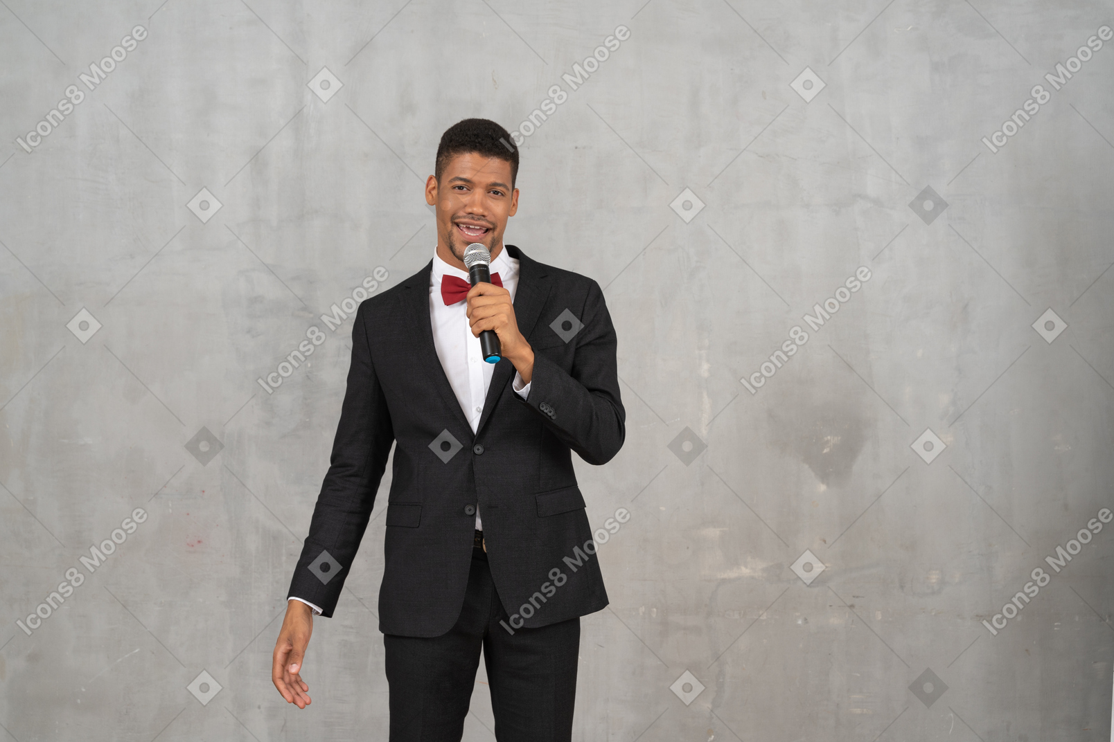 Мужчина в черном костюме поет в микрофон