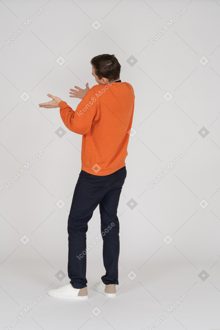 Young man in orange sweatshirt standing