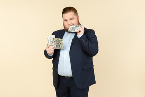 Un uomo taglie forti in un costume nero con banconote da un dollaro in mano