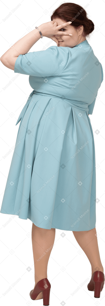 Vista posteriore di una donna in abito blu che mostra il segno v