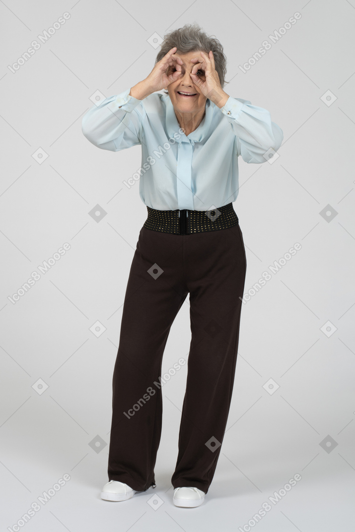 Old woman looking through imaginary binoculars