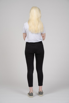 Back view of a young woman with folded arms