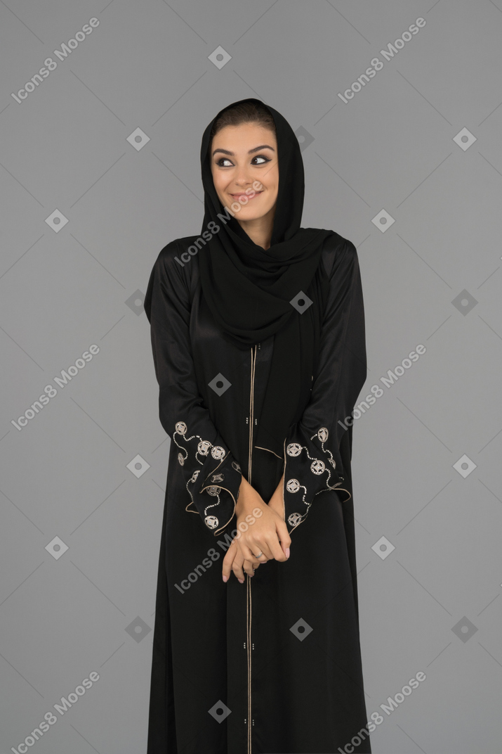 A cheerful muslim woman holding hands together
