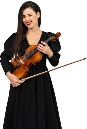 Close-up of a cheerful young lady in black dress holding the violin