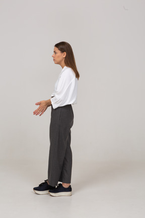 Vista lateral de uma jovem pensativa com roupa de escritório, de mãos dadas