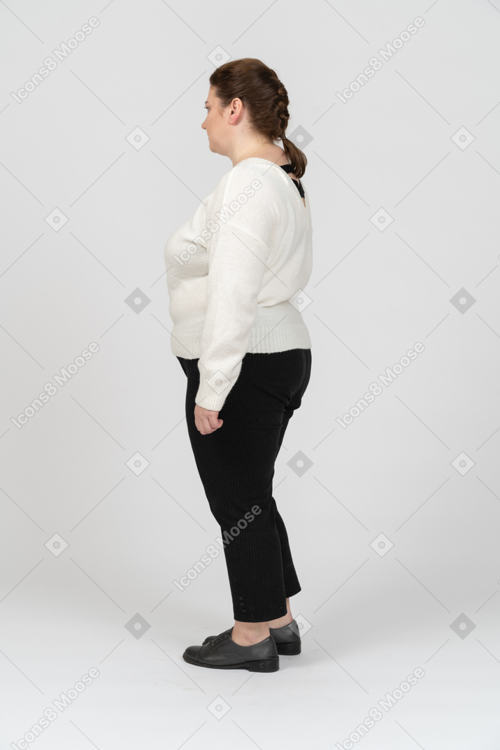 Полная женщина в повседневной одежде стоит в профиль