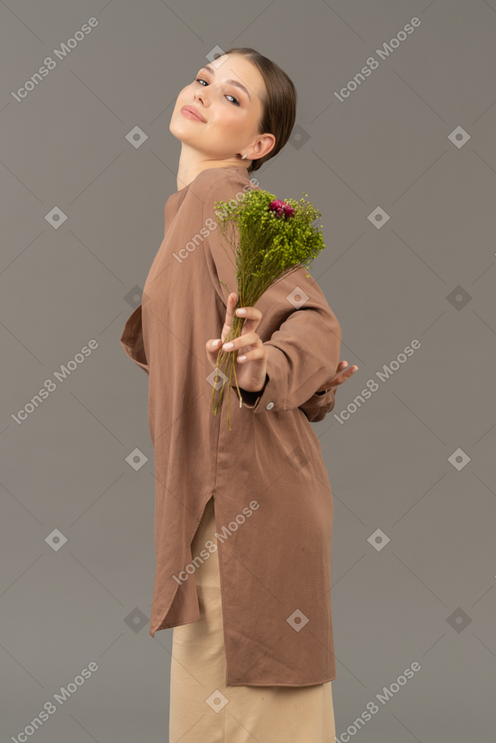 Mujer joven sonriente con flores de pradera