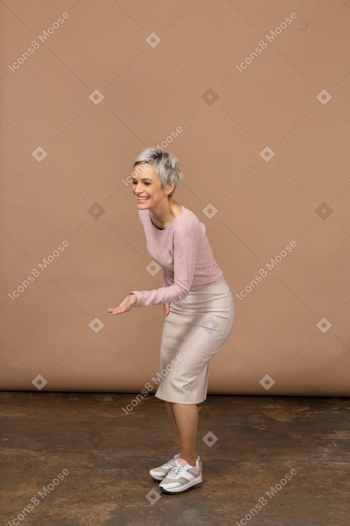 Side view of a woman in casual clothes making welcoming gesture