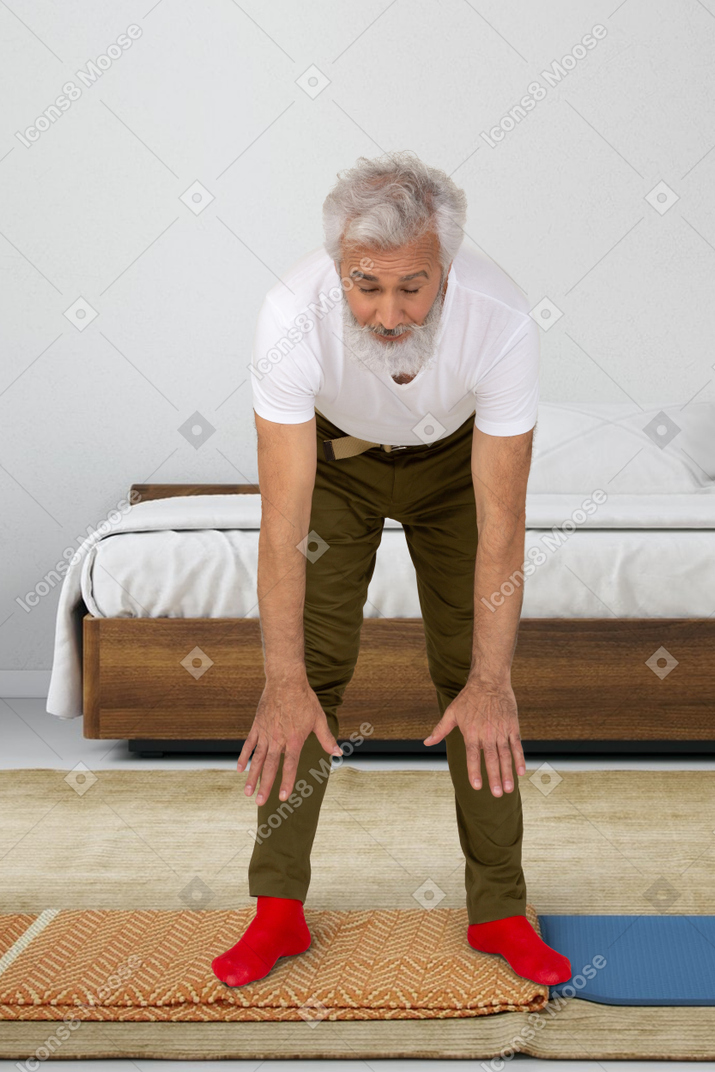 An old man doing exercises at home
