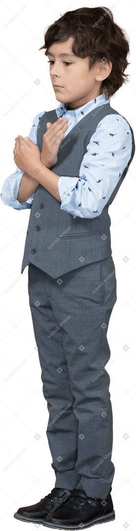 Side view of a boy in suit showing stop gesture