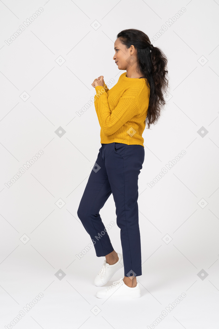 Side view of a girl in casual clothes showing heart sign