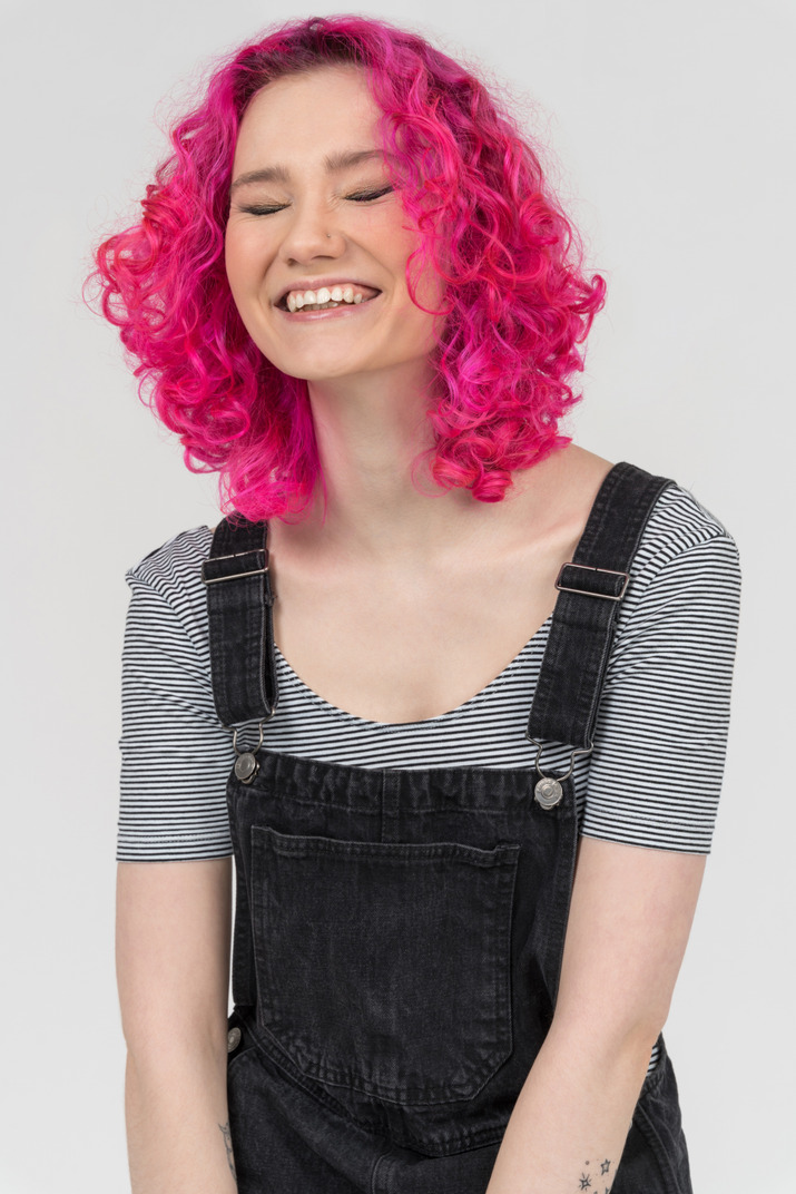 A cheerful pink haired girl laughing out loud
