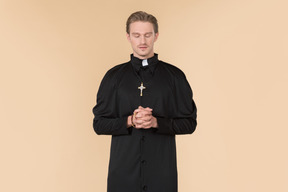 Catholic priest praying using prayer beads