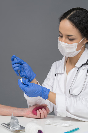 Female doctor ready to make a manupulation with syringe