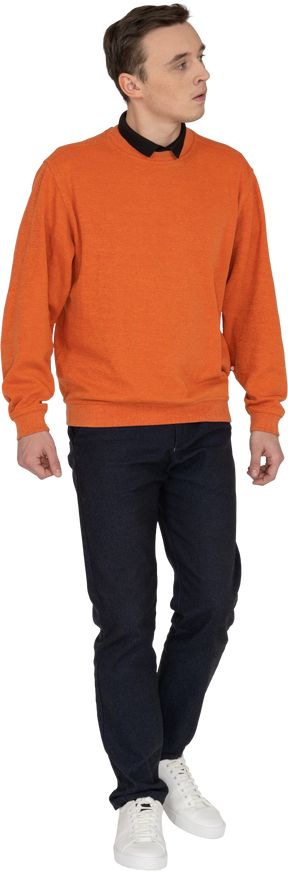 Jeune homme en sweat-shirt orange marchant