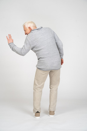 Rear view of man looking aside and showing three fingers
