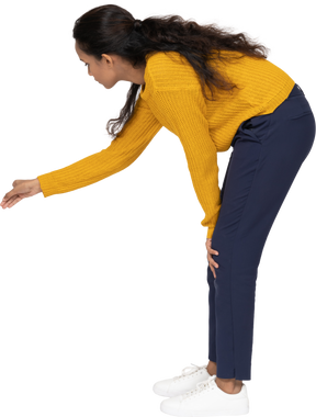 一个穿着休闲服的女孩用伸展的手臂弯下腰的侧视图