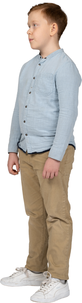 Vista lateral de um menino em roupas casuais parado